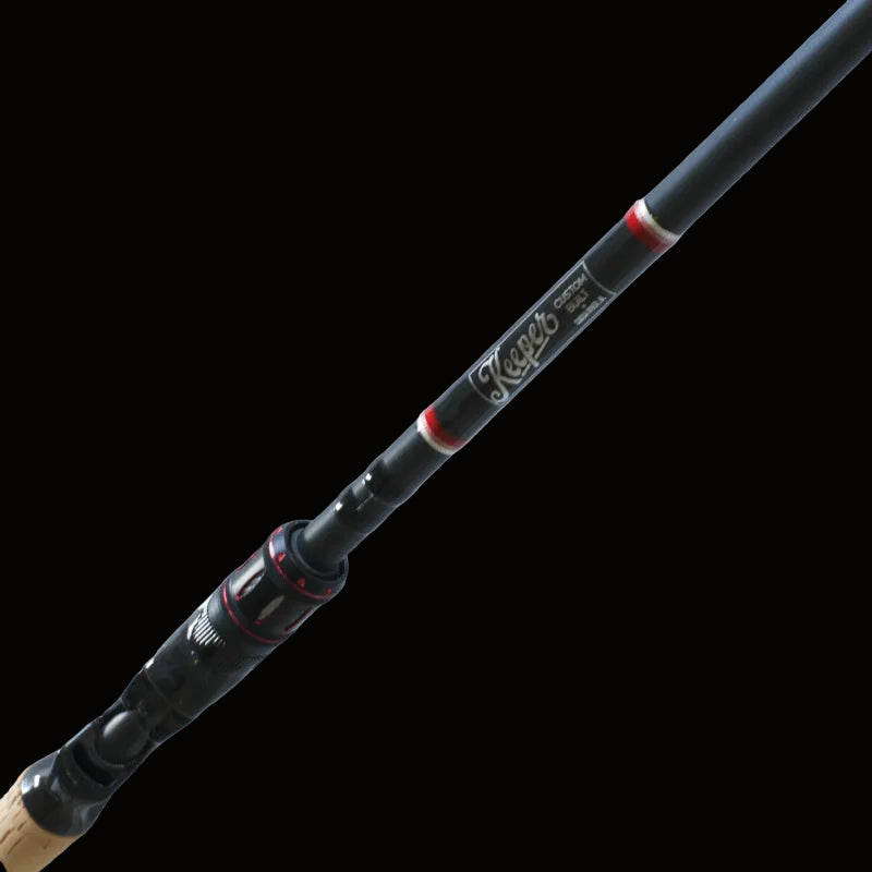 A close-up of the Keeper Rods-Doozie 7'6" Pitching/C-Rig Heavy Mod-Fast Precision Casting Rod, black with red accents and the brand name on the shaft, photographed against a light textured background.